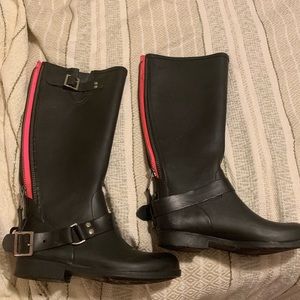 Black rain boots with pink zipper.